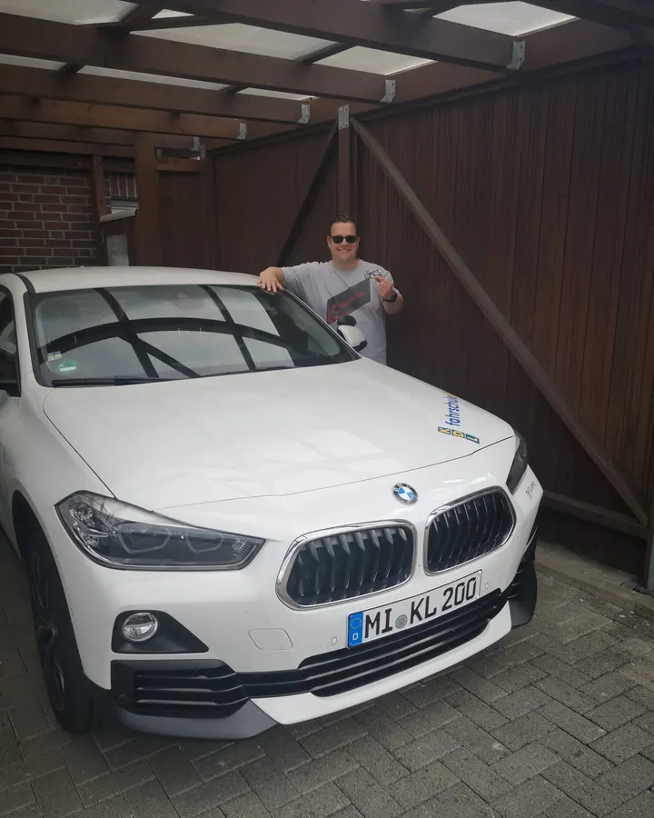 Frank Truschkowski neben einem weißen BMW